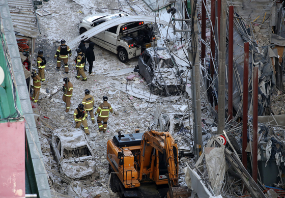 Firefighters and rescuers on Thursday search for workers who have been missing since a high-rise apartment being built in Gwangju partially collapsed on Tuesday. Five workers were accounted for as of Thursday. [YONHAP]