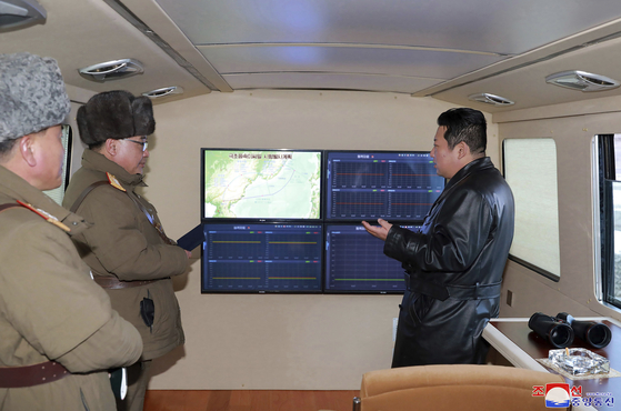 North Korean leader Kim Jong-un, right, monitors what Pyongyang claims to be a successful test of a hypersonic missile Tuesday in a photo released by its official Korean Central News Agency (KCNA) Wednesday. Hours later, the U.S. Treasury announced new sanctions on the North. [KCNA]