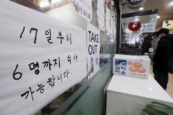 A notice posted at a restaurant in Seoul Friday states that starting from Jan. 17, up to six people can dine together after the government announced a slight easing of social distancing measures. [NEWS1] 