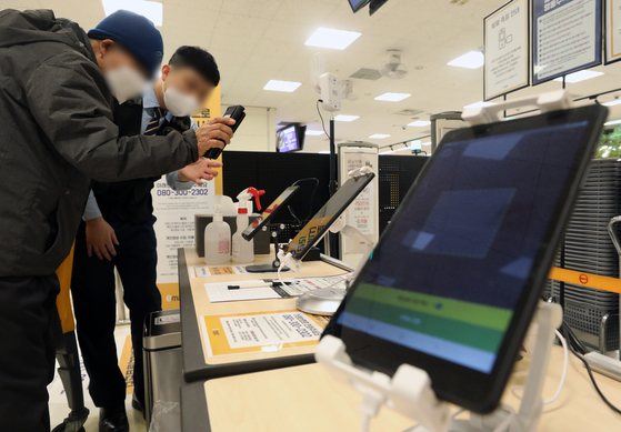 Customers at a large-sized supermarket in Seoul flash their QR codes before entering on Sunday. The vaccine pass system in place across supermarkets and department stores larger than 3,000 square meters (32,290 square feet) in Seoul has been lifted after a court decided to temporarily halt it, citing basic rights of people. Stores can still require customers to flash their QR codes to keep record of their entries and contact information in case an outbreak takes place. [NEWS1] 