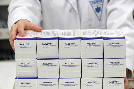A pharmacist shows boxes of Pfizer's oral pill Paxlovid to treat Covid-19, at a drugstore in Guro District, western Seoul on Sunday. While Korea began administrating the antiviral pills Friday, health authorities said among the nine patients that took the drug on the first day, many of them have showed signs of recovery. [NEWS1]