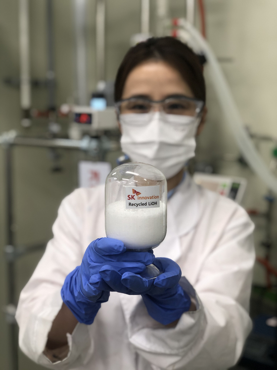 SK Innovation researcher holds up a bottle of recycled lithium hydroxide. [SK INNOVATION]