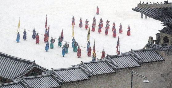 While snow falls across the country, a changing of guards ceremony takes place in the courtyard of Gyeongbok Palace in central Seoul on Wednesday. [NEWS1]