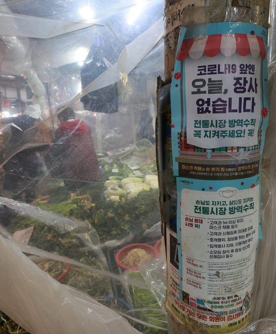 A notice on social distancing rules is posted at the Gyeongdong Market in Dongdaemun District, central Seoul, Wednesday. The registration period for financial support targeting small business owners and the self-employed began on Wednesday, and small business owners will be given 5 million won each. [YONHAP]