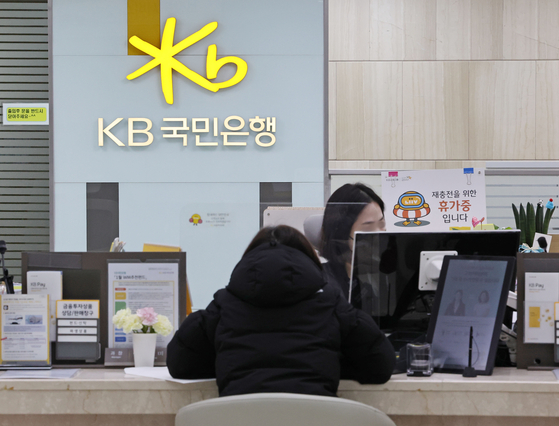 A customer consults a KB Kookmin Bank employee at a branch in Yeouido, western Seoul, on Thursday. The bank announced it would raise interest rates on savings accounts by as high as 0.4 percentage points starting Thursday. [YONHAP]