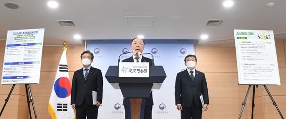 Finance Minister Hong Nam-ki, center, announces a 14 trillion-won supplementary budget, the first in 2022 and the seventh since the outbreak of Covid-19 in 2020, at the government office in Seoul on Friday. [MINISTRY OF ECONOMY AND FINANCE] 