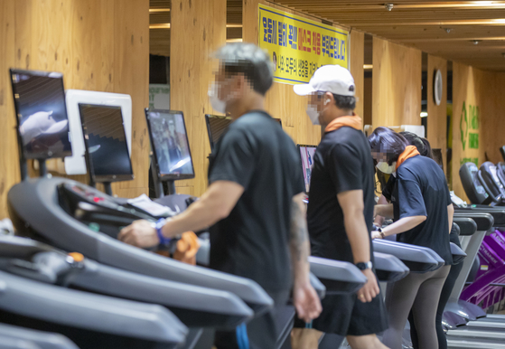 People exercise at a gym in western Seoul on June 13, 2021. Gyms across the country were one of the first venues to require vaccine passes, starting last November. [YONHAP]