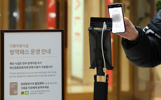 A customer flashes a QR code to prove his vaccination status upon entry to the Lotte Department Store’s main branch in Jung District, central Seoul, on Jan. 10, when the vaccine pass system was expanded to include large-sized department stores and supermarkets nationwide. The system has been halted across Seoul's large-sized department stores and supermarkets since Friday after a local court found the policy at risk of infringing on the unvaccinated people's rights to buy goods at some of the essential stores. [NEWS1]