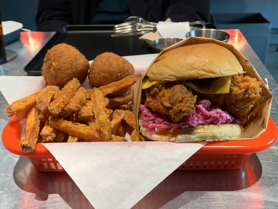 A Nashville Hot Chicken Sandwich with a side of sweet potato fries and mac n cheese balls at ckbg.lab in Itaewon, central Seoul. [LEE JIAN]