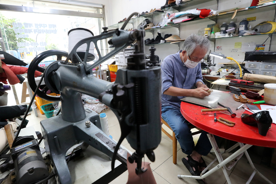 A shoemaker makes shoes at a workshop at Seongsu-dong, eastern Seoul. [NEWS1]
