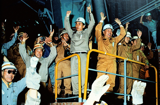 Former Posco Chairman Park Tae-joon, center, cheers with employees after the first production of crude steel at its Pohang No. 1 blast furnace in 1973. [POSCO]