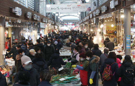 Residents shop for groceries and traditional tableware for the ancestral rite ceremonies for Lunar New Year at a traditional market in Dongdaemun District, eastern Seoul, on Sunday. [NEWS1]
