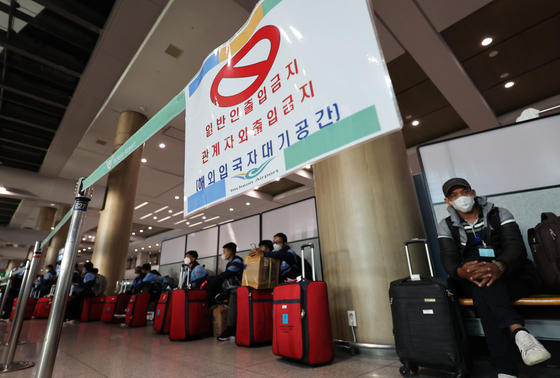 A group of Singaporean tourists wait at Incheon International Airport on Monday after the two countries resumed a travel bubble pact that allows quarantine-free travel. [YONHAP]