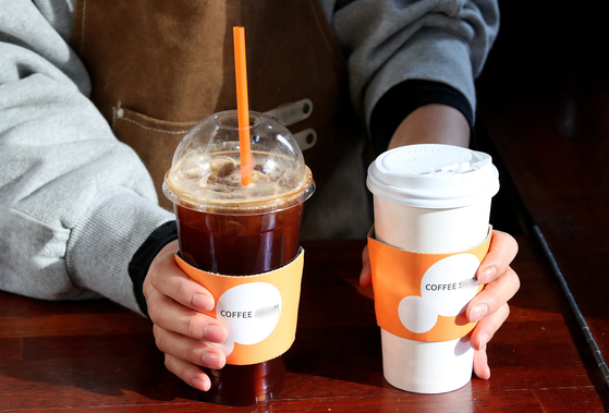 A single-use plastic cup and paper cup being served at a cafe in Seoul on Jan. 6. [NEWS1] 