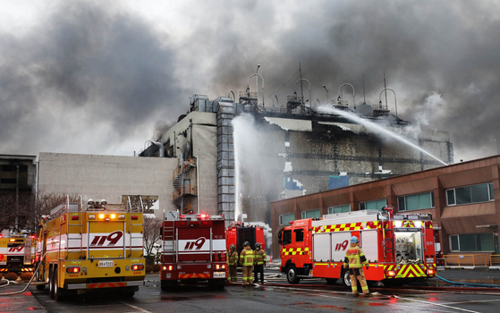 Firefighters on Monday fight a blaze that broke out at a seven-story synthetic fiber manufacturing factory in the southeastern city of Ulsan the previous evening. [YONHAP]
