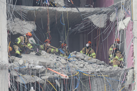 Emergency workers remove debris from the 30th floor of a 39-story apartment building under construction in Gwangju on Tuesday. The building's facade partially collapsed on Jan. 11 as workers were pouring concrete on the rooftop. [YONHAP]