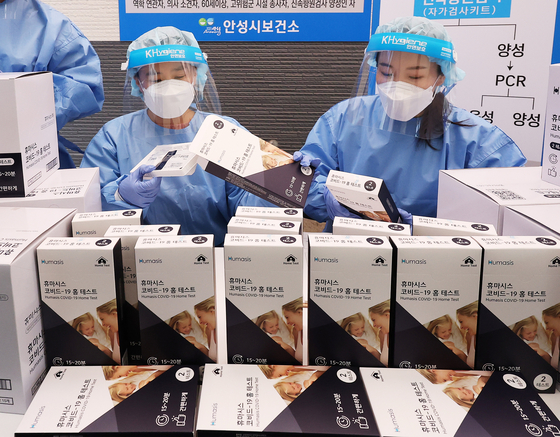 Medical workers check Covid-19 self-test kits at a public health center in Anseong, Gyeonggi, one day before polymerase chain reaction (PCR) tests will only be offered to high-risk groups in four Omicron variant-dominated areas: Gwangju, South Jeolla, Pyeongtaek and Anseong. [YONHAP]
