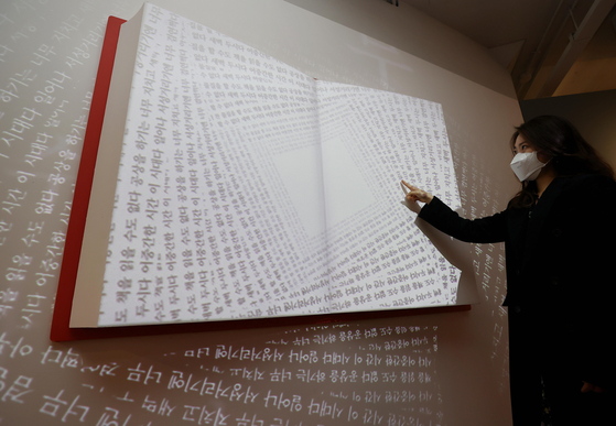 An employee at the National Museum of Korean Contemporary History examines an installation on Tuesday for a new exhibition based on best-selling books in Korea. The museum will display top-selling books starting Tuesday for an unspecified period. [YONHAP]