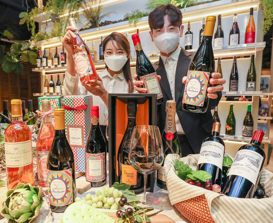 Models hold up bottles of wine at Hyundai Department Store’s Trade Center Store in Gangnam District, southern Seoul. Hyundai Department Store announced Thursday that it will offer luxury wines at its sixteen branches until Jan. 31. [YONHAP]