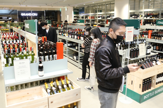 Customers shop at Bottle Bunker, a specialty wine store that opened at Zettaplex last December. [LOTTE MART]