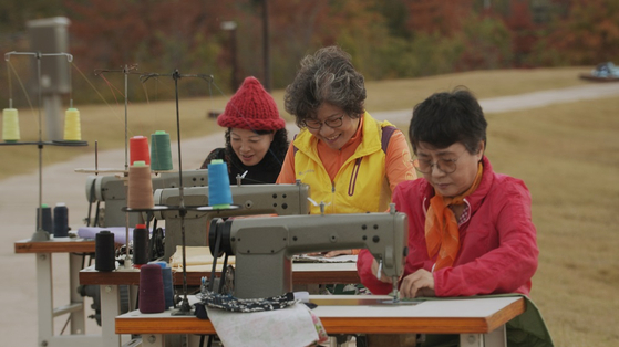 From left, Im Mi-kyung, Shin Soon-ae and Lee Suk-hee start to sew each other's names on pieces of cloth. [JIN JIN PICTURES] 