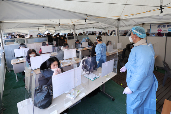 Medical staff monitor people taking Covid-19 rapid antigen tests at the Songpa District Public Health Center in southern Seoul Thursday morning. [YONHAP]
