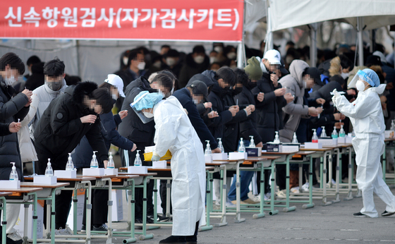 People line up to get a rapid antigen test at a health center in Daejeon Friday as the country saw a record 27,443 new cases. [KIM SEONG-TAE]