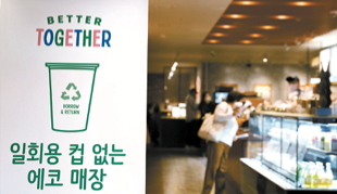 A Starbucks cafe in central Seoul puts up a banner about phasing out of single-use plastic cups on Nov. 7, 2021. [NEWS1]