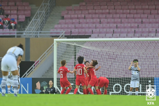Korean players watch on as the Chinese team celebrates after winning the 2022 Women’s Asian Cup 3-2 at DY Patil Stadium in Navi Mumbai, India on Sunday. [NEWS1]