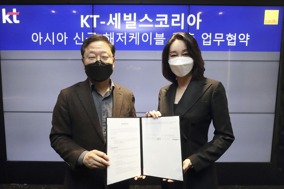 Shin Soo-jung, senior executive vice president at KT, at left, and Lee Soo-jeong, CEO of Savills Korea, pose for photo after signing an agreement to build a new undersea optic cable in the Asia-Pacific region on Monday. [KT]
