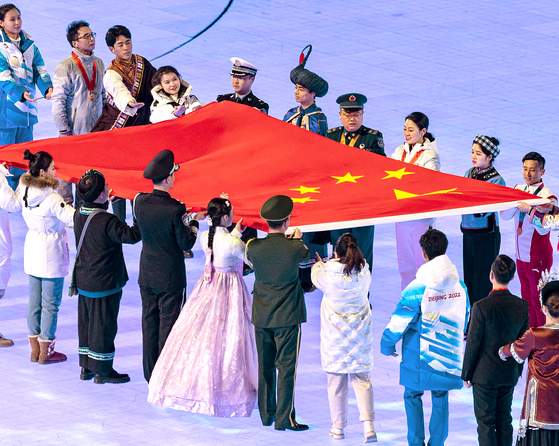 Among the representatives of ethnic minorities in China carrying the national flag of the country, at the opening ceremony of the Beijing Winter Olympics on Friday, there is a woman who appears to be wearing hanbok, a Korean traditional dress. [YONHAP]