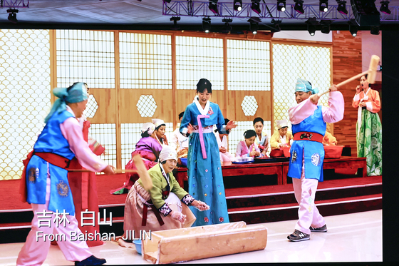 In a video streamed during a ceremony rehearsal introducing the traditional costumes and activities per region in China, footage shows several people appearing to be making rice cakes, wearing costumes similar to hanbok. [YONHAP]