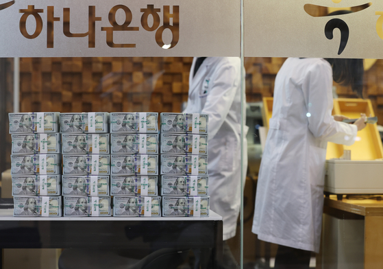 Employees at a Hana Bank branch in Jung District, central Seoul, organize stacks of dollar bills on Monday. Foreign exchange reserve decreased by $1.6 billion last month to $461.5 billion, shrinking for a third consecutive month, Bank of Korea announced Monday. [YONHAP]