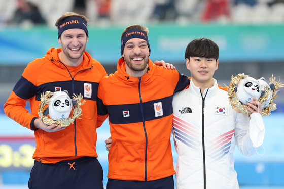 Kim Min-seok, right, celebrates winning the men's speed skating 1500-meter bronze medal with gold medalist Kjeld Nuis, center and silver medalist Thomas Krol of the Netherlands at the Beijing 2022 Olympic Games podium in Beijing on Tuesday. [JOONGANG ILBO]