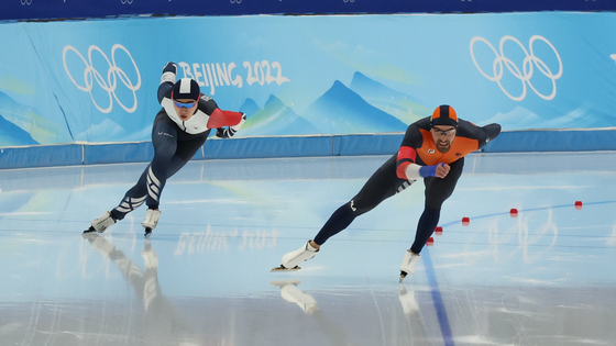 Kim Min-seok, left, races alongside Kjeld Nuis of the Netherlands during the men's speed skating 1500-meter event at the Beijing 2022 Olympic Games in Beijing on Tuesday. [EPA/YONHAP]