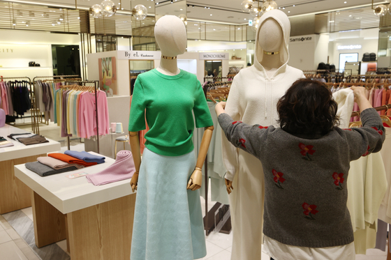 A staffer dresses a mannequin with spring clothes at a department store in Seoul on Tuesday. According to Statistics Korea, consumers last year increased purchases of fashion goods including clothes and handbag. Sales of semi-durable goods including fashion items rose 12.4 percent, faster than the overall retail increase of 5.5 percent. [YONHAP] 
