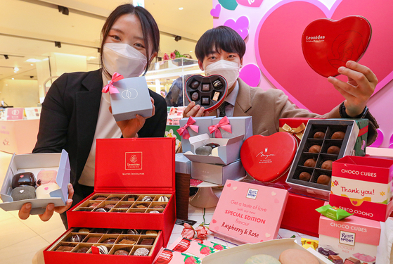 Employees hold up dessert gift packages at Hyundai Department Store’s Trade Center branch in Gangnam District, southern Seoul. Hyundai Department Store announced Wednesday that it will offer dessert gift packages ahead of Valentine's Day at its sixteen branches until Feb. 15. [YONHAP]
