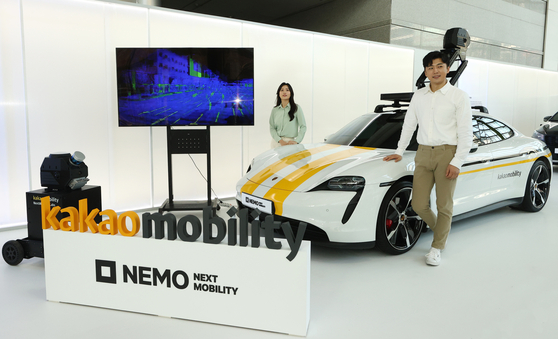 Models introduce the self-driving robots and a Porsche Taycan equipped with the sensors needed for building Kakao Mobility's digital twin, during the “Next Mobility: NEMO 2022” held in Coex, southern Seoul, Thursday. [YONHAP] 