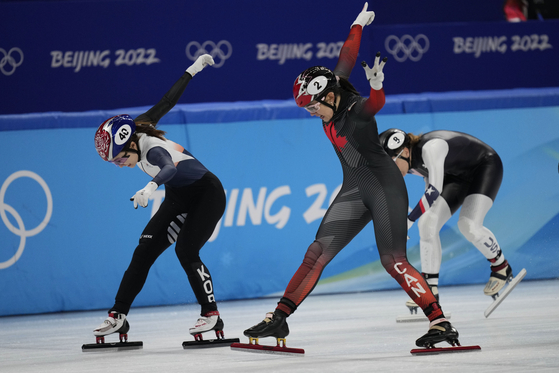 Choi Min-jeong, left, and Courtney Sarault of Canada, cross the finish line in the women's 3000-meters relay semifinal during the short track speedskating competition at the 2022 Winter Olympics on Wednesday. [AP/YONHAP]