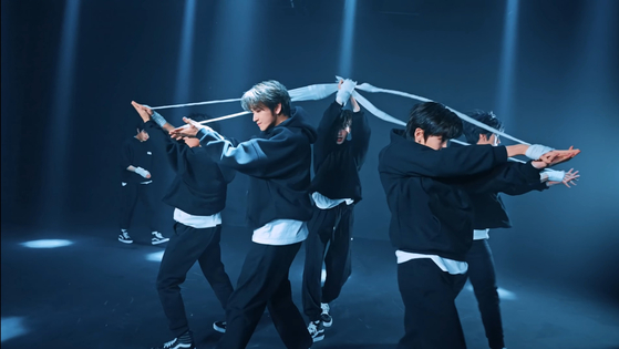 The choreography of Trendz's song “Villain” showcases intense dance sequences involving bandages which see members dance while connected to each other. [SCREEN CAPTURE]