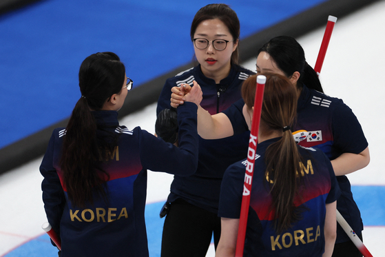 Team Korea celebrate after beating the Russian Olympic Committee 9-5 in a round robin curling game at the National Aquatics Center in Beijing on Saturday. [REUTERS/YONHAP]