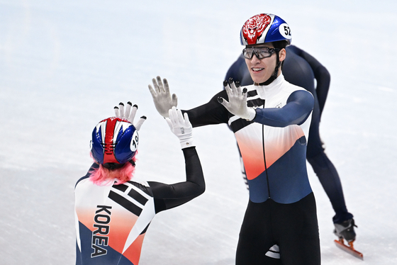 Hwang Dae-heon, right, celebrates with countryman Kwak Yoon-gy after the men's 5,000-meter relay semifinal at the Capital Indoor Stadium in Beijing on Friday. [XINUHA/YONHAP]