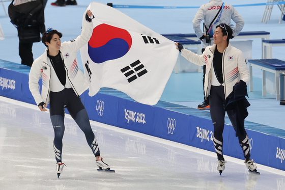 Cha Min-kyu, left, celebrates with Kim Jun-ho after winning the men's 500-meter silver medal at the National Speed Skating Oval in Beijing on Saturday. [NEWS1]
