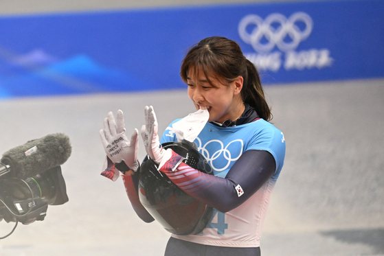 Kim Eun-ji holds up a message saying "I am proud to represent Korea, Go Team Korea!" on her hands for a camera after finishing her third run in the women's skeleton event at the Yanqing National Sliding Centre during the Beijing 2022 Winter Olympic Games in Yanqing on Sunday. [AFP/YONHAP]