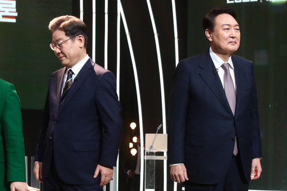 Democratic Party candidate Lee Jae-myung, left, with People Power Party candidate Yoon Suk-yeol, at their first televised debate on Feb. 3 held in Yeouido, Seoul. [YONHAP] 
