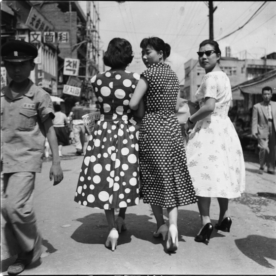 A picture taken by photographer Shin Sang-woo in the 1950s shows women wearing polka-dot or flower-patterned dresses with heels. [SEOUL URBAN LIFE MUSEUM]