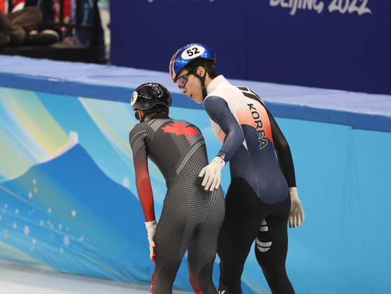 Hwang Dae-heon, right, talks to Steven Dubois of Canada after colliding in his men's 500-meter semifinal during the short track speed skating competition at the 2022 Winter Olympics on Sunday. [NEWS1]