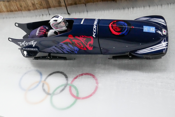 Suk Young-jin and Kim Hyeong-geun slide down the track during the first heat of the two-man bobsleigh at the 2022 Winter Olympics on Monday. [AP/YONHAP]