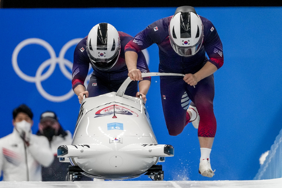 Won Yun-jong and Kim Jin-su launch their sleigh at the start of their run in the first heat of the two-man bobsleigh at the 2022 Winter Olympics on Monday. [AP/YONHAP]