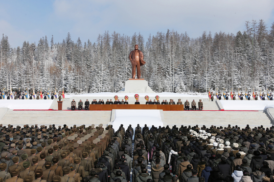 North Korean officials pay tribute Tuesday to late leader Kim Jong-il in front of his statue in Samjiyon, Ryanggang Province, in this photo released by state-run newspaper Rodong Sinmun on Wednesday. [YONHAP]